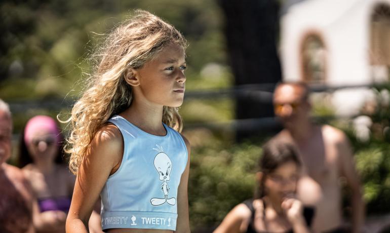 Bambina con top di Tweety in una giornata soleggiata all'aperto.