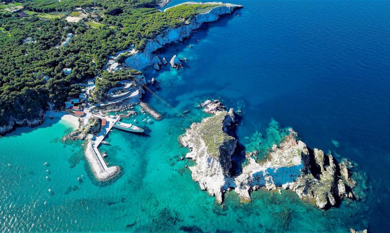 Vista aerea di una costa rocciosa con acque cristalline.